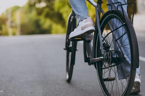 Ein Fahrrad liegt seitlich abgestellt auf dem Asphalt einer Straße.