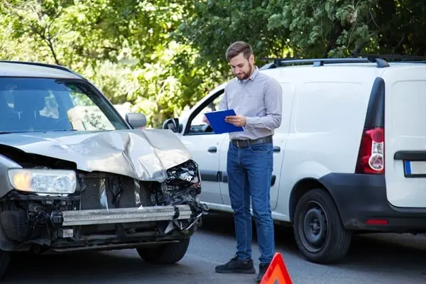 Ein Autofahrer benutzt sein Smartphone während der Fahrt und erschrickt sich.